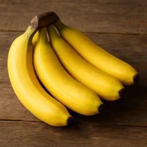 A ripe bunch of Indian bananas arranged on a rustic wooden surface, showcasing their natural yellow color and export-quality freshness.