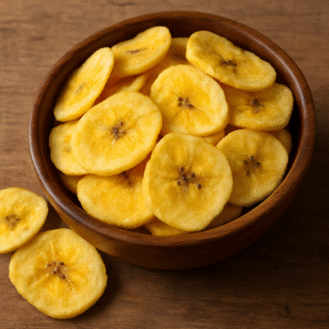 A close-up view of crispy Indian banana chips arranged in a wooden bowl on a rustic surface, highlighting their golden texture and export-quality appeal.