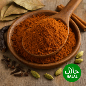 A heap of reddish-brown meat masala powder surrounded by whole spices on a rustic wooden surface, representing a traditional halal Indian spice mix ideal for mutton and meat curry preparations.