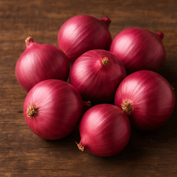A group of fresh red onions with glossy skins arranged on a rustic wooden surface, ideal for international export and wholesale supply.