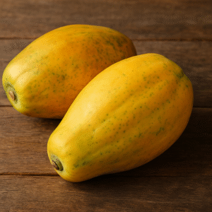 Two ripe Indian papayas placed on a rustic wooden surface, showcasing their vibrant yellow-orange skin and natural texture, ideal for fresh fruit export.